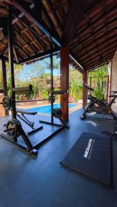 um ginásio com 2 bicicletas de exercício e uma piscina em Hotel Pousada Marambaia em Arraial d'Ajuda