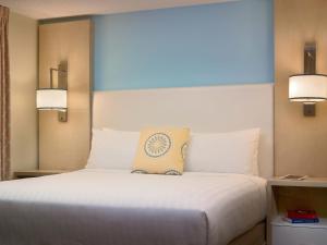 a bedroom with a large white bed with two lights at Parsippany Suites Hotel in Parsippany