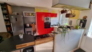 a kitchen with red cabinets and a black counter top at Hâvre de paix in Broons