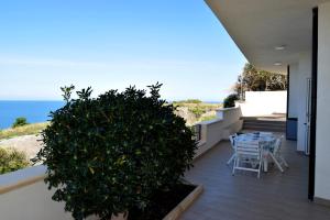 een balkon met een tafel en stoelen en de oceaan bij Casa Framaibla - la veranda sull'Etna in Augusta