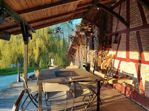 una mesa y sillas en el porche de una casa en LE DOMAINE DU SENS en Frontenaud