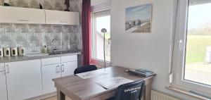 a kitchen with a wooden table and a sink at B&B Koningsbosch in Koningsbosch