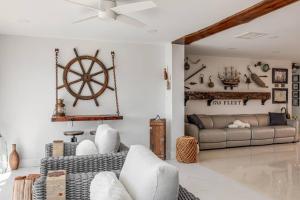 a living room with a couch and a steering wheel on the wall at Pearl Luxury Poolcanal Shipwreck History Hunt Fun in Cocoa Beach
