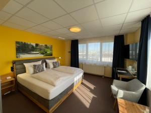 une chambre d'hôtel avec un lit et une chaise dans l'établissement Parkhotel Marzahn, à Berlin
