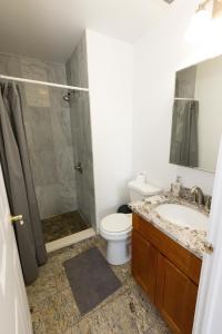 La salle de bains est pourvue de toilettes, d'un lavabo et d'une douche. dans l'établissement Chic 2BR Retreat with Skyline Views near NYC, à Union City