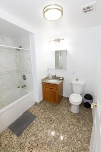 La salle de bains est pourvue de toilettes, d'une baignoire et d'un lavabo. dans l'établissement Chic 2BR Retreat with Skyline Views near NYC, à Union City