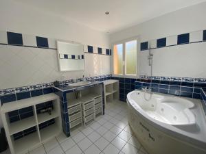 a blue and white bathroom with a tub and a sink at Villa Giens - Plage à pied -9 couchages in Hyères +54 photos