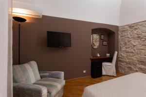 ein Wohnzimmer mit einem Sofa und einem TV an der Wand in der Unterkunft Palazzo Cosentino in Caltanissetta