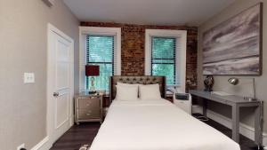 1 dormitorio con 1 cama, escritorio y ventanas en Premier Suites Bay Village en Boston