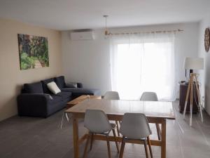 a living room with a table and chairs and a couch at Maison 6-8 personnes 3 chambres in Les Pieux +6 photos