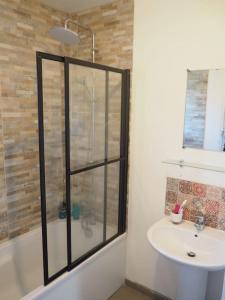 a bathroom with a glass shower and a sink at Maison 6-8 personnes 3 chambres in Les Pieux