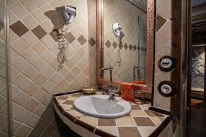 a bathroom with a sink and phones on the wall at Hotel Xaluca Dades in Boumalne