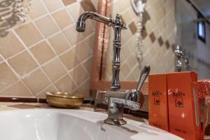 a sink with a faucet in a bathroom at Hotel Xaluca Dades in Boumalne