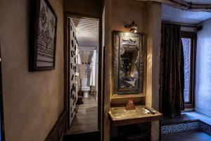 a hallway with a bathroom with a sink and a mirror at Hotel Xaluca Dades in Boumalne