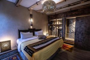 a bedroom with a bed and a chandelier at Hotel Xaluca Dades in Boumalne