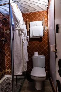 a bathroom with a toilet and towels at Hotel Xaluca Dades in Boumalne