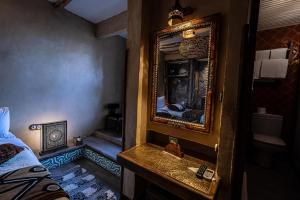a bathroom with a mirror and a sink in a room at Hotel Xaluca Dades in Boumalne