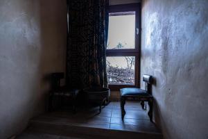 a room with a window and two chairs and a window istg at Hotel Xaluca Dades in Boumalne