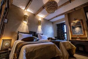 a bedroom with two beds in a room at Hotel Xaluca Dades in Boumalne