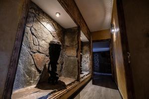 a hallway with a stone wall in a house at Hotel Xaluca Dades in Boumalne