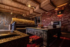 a room with a bed and a table and a couch at Hotel Xaluca Dades in Boumalne