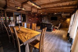 a dining room with a wooden table and chairs at Hotel Xaluca Dades in Boumalne