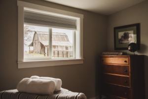 a bedroom with a window and a dresser and a barn at The Heritage House in Klamath Falls