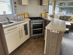 a kitchen with a sink and a stove top oven at D34 Steeple Bay Caravan Site in Chelmsford