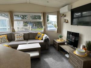 a living room with a couch and a tv at D34 Steeple Bay Caravan Site in Chelmsford