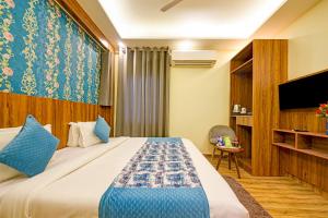 a hotel room with a bed and a tv at Roseewood Hotel Near Delhi International Airport in New Delhi