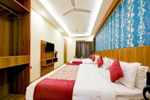 a hotel room with two beds and a tv at Roseewood Hotel Near Delhi International Airport in New Delhi