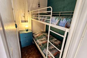 two bunk beds in a small room with a mirror at Logis des Palmiers YourHostHelper in Gruissan