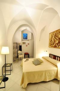 - une chambre avec un lit et une chaise dans l'établissement Le Volte with pool by Amalfivacation, à Amalfi