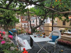 eine Terrasse mit einem Tisch und Stühlen unter einem Baum in der Unterkunft Le Volte with pool by Amalfivacation in Amalfi