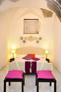 - une chambre avec un lit blanc et des coussins violets dans l'établissement Le Volte with pool by Amalfivacation, à Amalfi