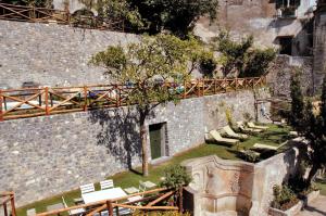 eine Steinmauer mit einem Haufen Stühle und einer Brücke in der Unterkunft Le Volte with pool by Amalfivacation in Amalfi