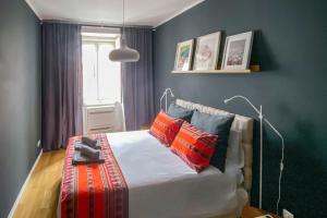 a bedroom with a bed with red and black pillows at Lisbon deluxe city center flat in Lisbon