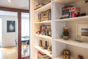 a room with white shelves filled with books at Lisbon deluxe city center flat in Lisbon