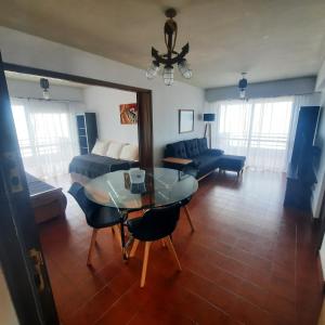 sala de estar con mesa y sofá en Arpon 9 - 5C - Frente al mar 2 dorm. cochera privada en Villa Gesell