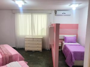 a bedroom with two beds and a dresser and a window at pousada da sarafina ltda in Salvador +75 photos