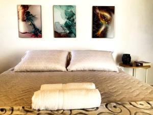 a bedroom with a bed with four pictures on the wall at Casa Río donde guardamos un secreto encantador in Montería