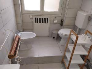 La petite salle de bains est pourvue de toilettes et d'un lavabo. dans l'établissement Affittacamere Polese, à Bologne