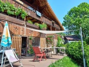 eine Terrasse mit Stühlen, einem Tisch und einem Sonnenschirm in der Unterkunft Niesenblick in Aeschlen