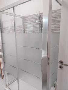 La salle de bains est pourvue d'une douche en verre et de murs blancs. dans l'établissement Affittacamere Polese, à Bologne