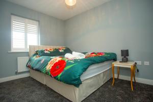a bedroom with a bed with a green comforter at Rosina grove ebbsfleet in Swanscombe
