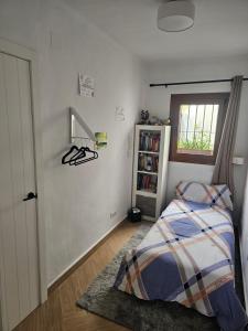 um quarto com uma cama e uma estante de livros em Casa Isis Garden em Matalascañas