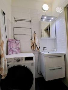 een badkamer met een wasmachine en een wastafel bij Renovated 64m2 apartment in Helsinki