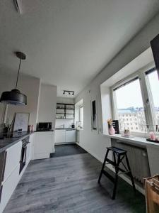 a large white kitchen with a counter and a window at Renovated 64m2 apartment in Helsinki