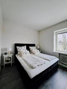 biała sypialnia z dużym łóżkiem i oknem w obiekcie Renovated 64m2 apartment w Helsinkach