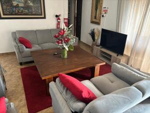 ein Wohnzimmer mit einem Tisch, Sofas und einem TV in der Unterkunft Sofros To Apomero 